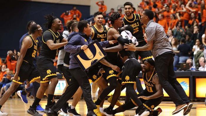 A group of male basketball players come together and celebrate.